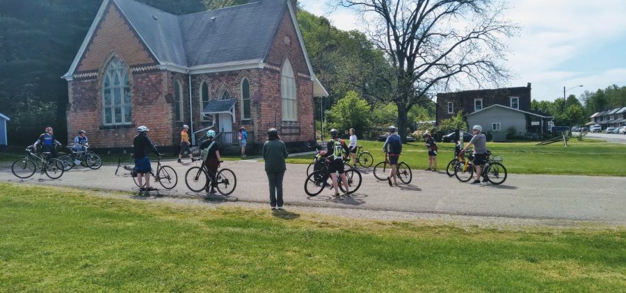 An image of people with bikes in front of a church.