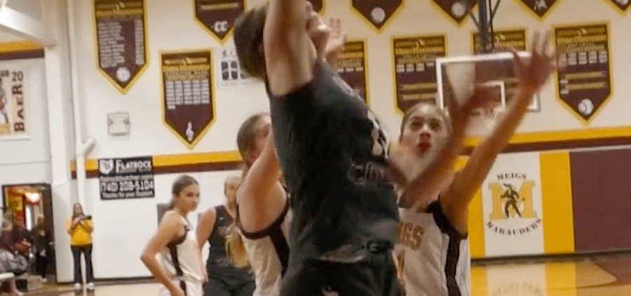 Vinton County player jumps at the rim while Meigs players attempt to block