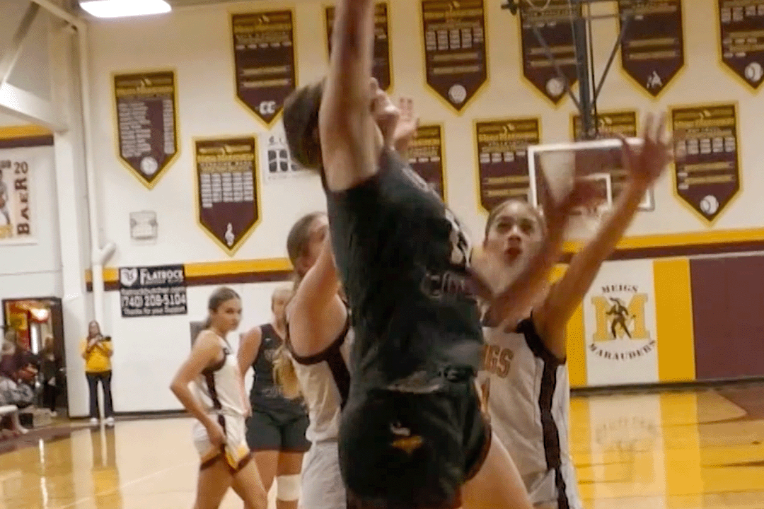 Vinton County player jumps at the rim while Meigs players attempt to block