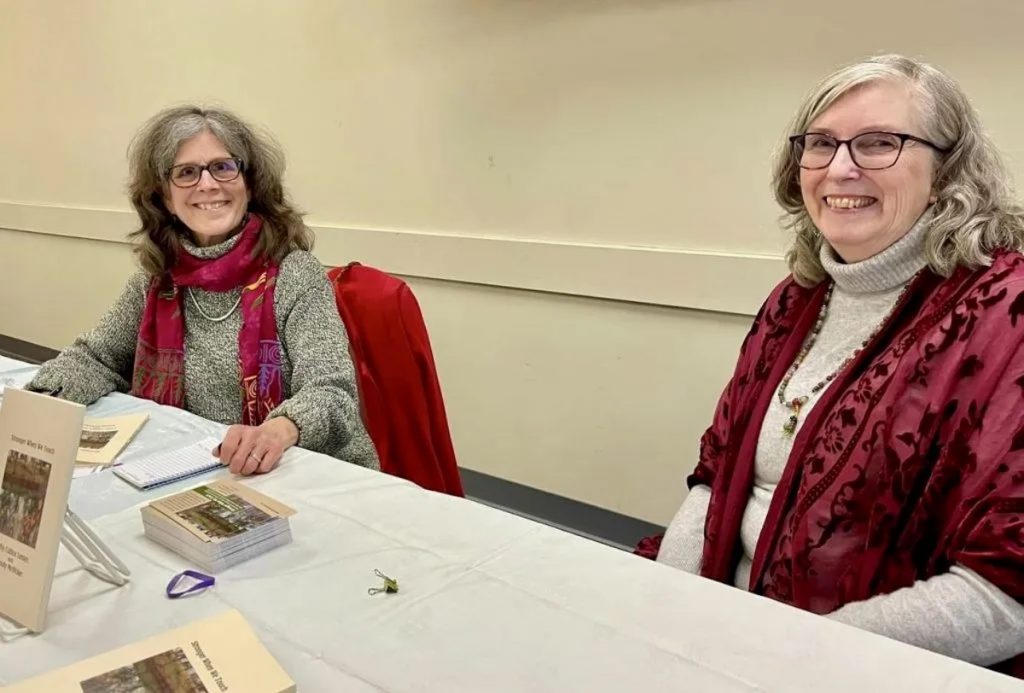 An image of authors Wendy McVicker and Cathy Cultice Lentes seated at an event for their book, "Stronger When We Touch." 