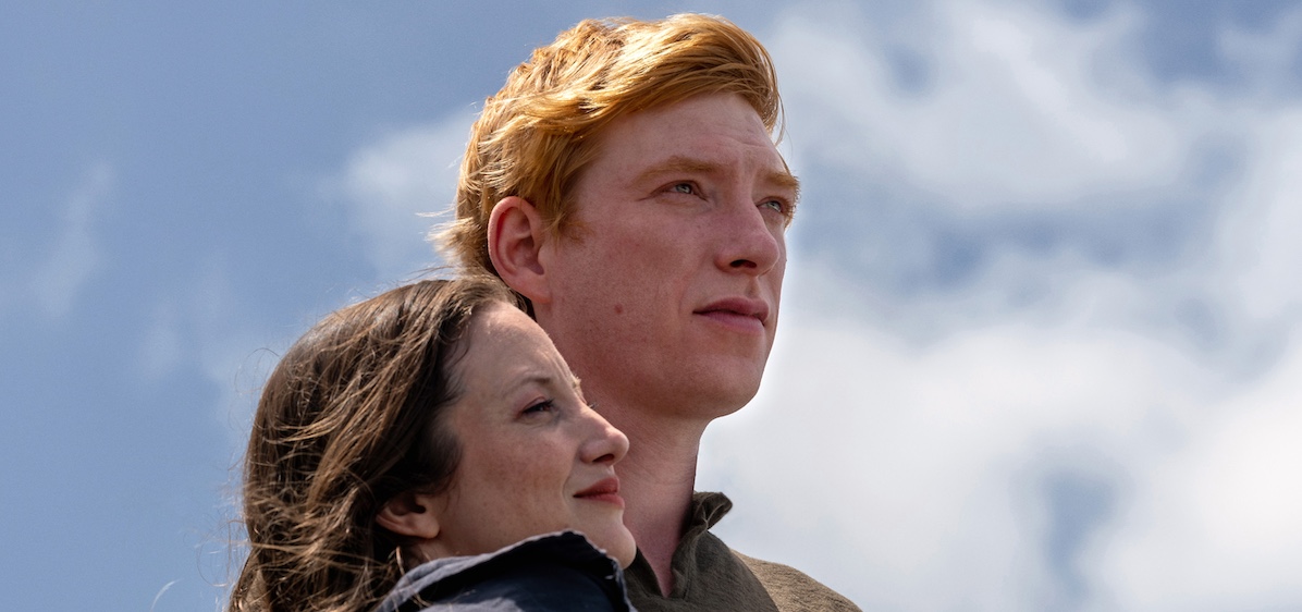 Andrea Riseborough as Alice and Domhnall Gleeson as Jack. Hugging with blue sky in the background