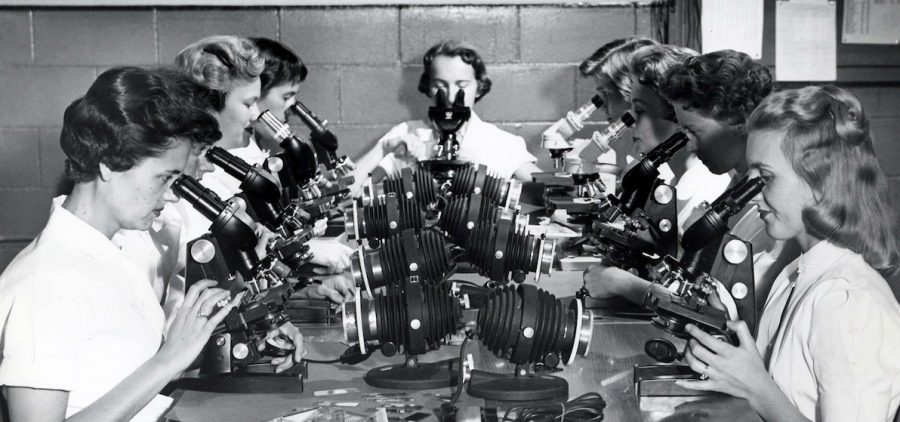 Female Cytologists at the clinical trials in Memphis, Tennessee. All nine of the women looking through microscopes at the same table Credit:Courtesy of University of Tennessee