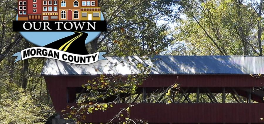 covered bridge in Ohio surrounded by green brush and trees, logo for "Our Town: Morgan County"