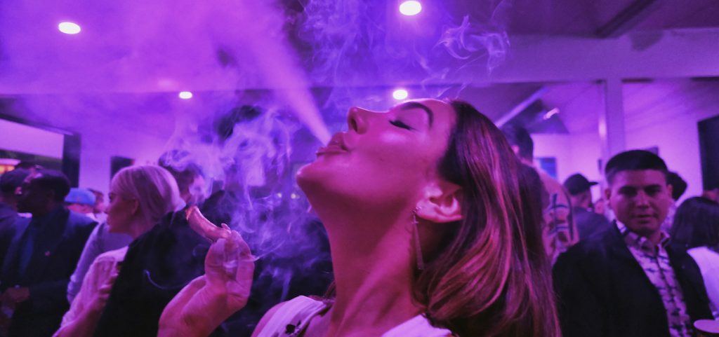A guest takes a puff from a marijuana cigarette at the Sensi Magazine party celebrating the 420 holiday in the Bel Air section of Los Angeles, April 20, 2019.