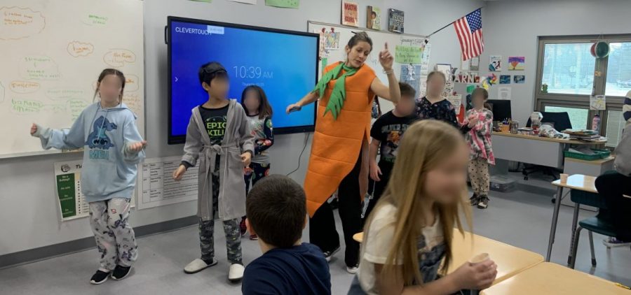 Molly Wales dances in her carrot costume during a smoothie party at the front of the classroom with students at The Plains Intermediate School.