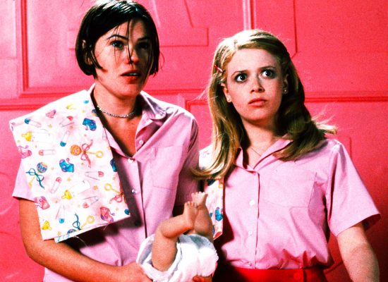 A still from the film "But I'm a Cheerleader." Two people wearing pink are pictured against a pink wall.