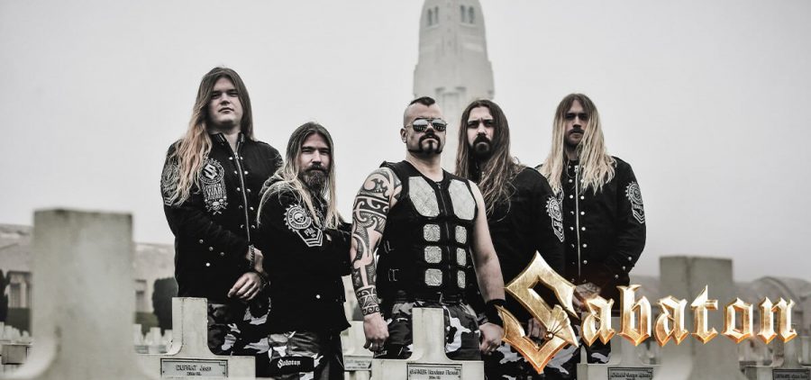 A promotional image of the band Sabaton. All the band members are wearing black and are posed outside against a gray landscape.