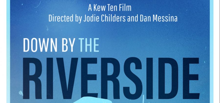 An image of the poster for the film "Down by the Riverside." The poster shows the profile of a person looking out over a river.