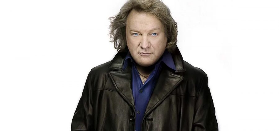 A promotional image of former Foreigner singer Lou Gramm. He is against a white background and wearing a leather jacket.