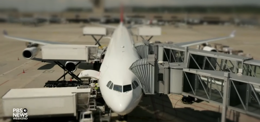 A plane sits at an airport gate.