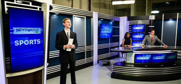 Students standing on NewsWatch set
