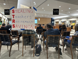 A sign put up on the window of the STRS board meeting room reads "Stealing Teachers Retirement Funds."