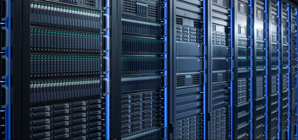 Server Racks and Cabinets full of Hard Drives inside Large Data Center.