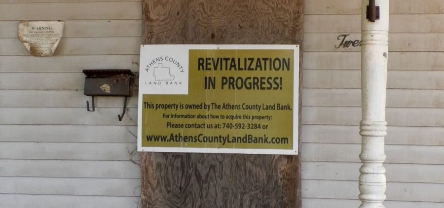 Athens County Land Bank has a sign on a Nelsonville house that says revitalization is in progress. The house will be torn down to create new affordable housing.