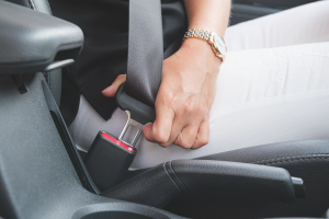 A person buckles a seat belt.
