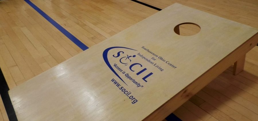A cornhole board with the logo for the Southeastern Ohio Center for Independent Living logo.
