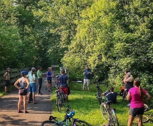 An image of people on an outdoor bike path in the woods.
