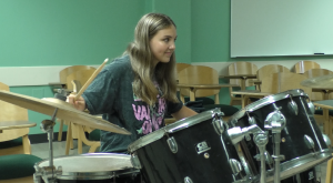 Harper Fickle learns how to play the drums at Athens Rock Camp for Girls.