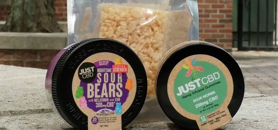 Two containers of hemp gummies sitting in front of a hemp-infused Rice Krispie treat.