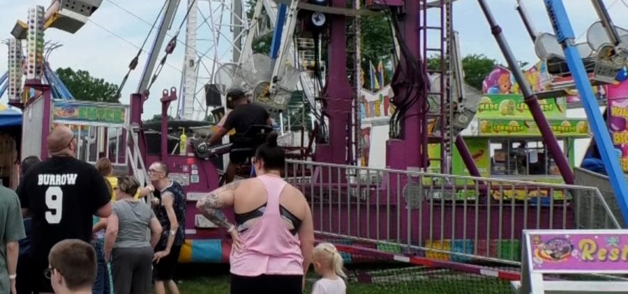 People are waiting in line at the Lawrence County Fair for the Ferris Wheel.
