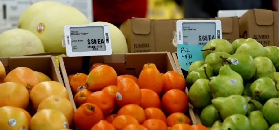 Fresh produce is on display at a grocery store. Small digital screens take the place of a traditional price tag, showing the cost of the food.