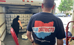 Two people unload boxes of signatures for a redistricting initiative from a U-haul.