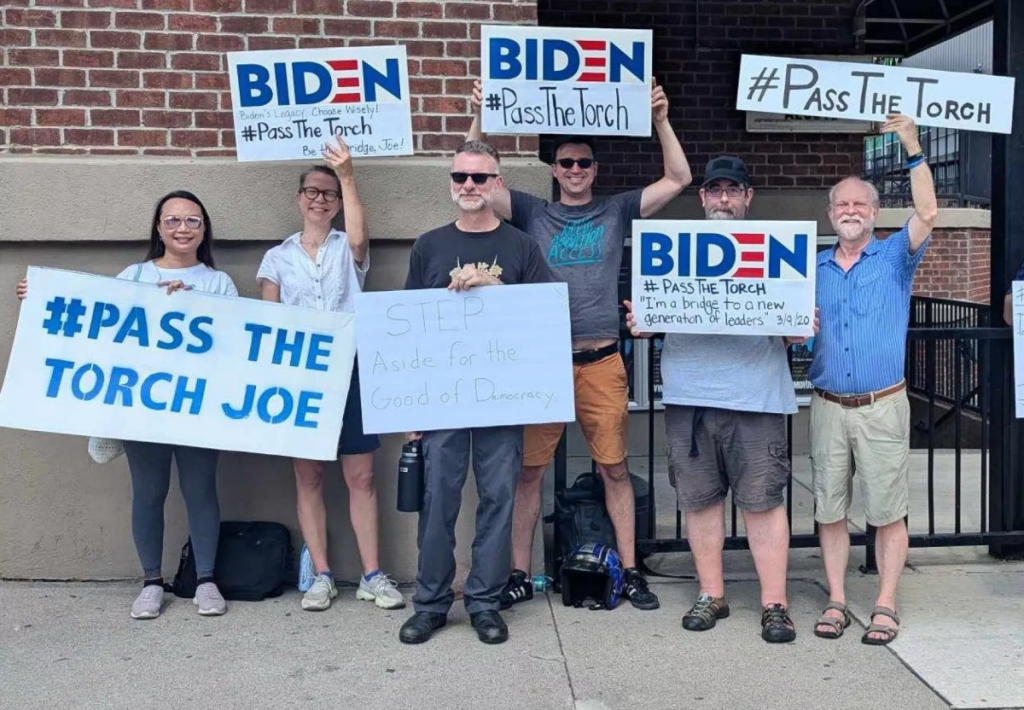 A group of Democratic activists hold signs calling on Biden to drop out of the race.