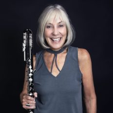 A promotional photo of Ali Ryerson. She is posed against a black background.