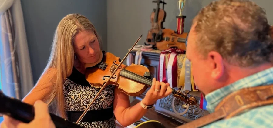 Kerry Varble plays her fiddle with an accompanying guitar player.