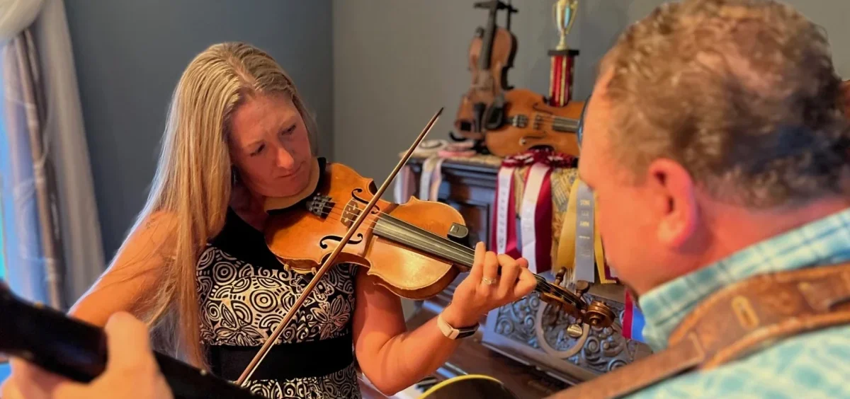 Kerry Varble plays her fiddle with an accompanying guitar player.