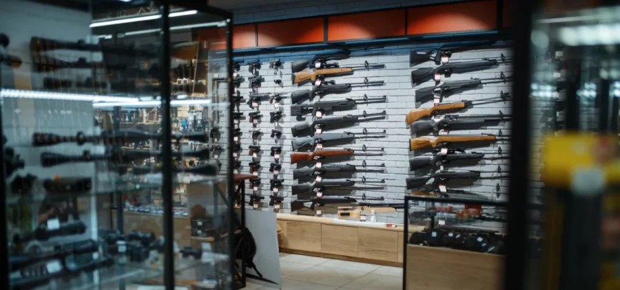 Displays of various guns are shown in a gun store