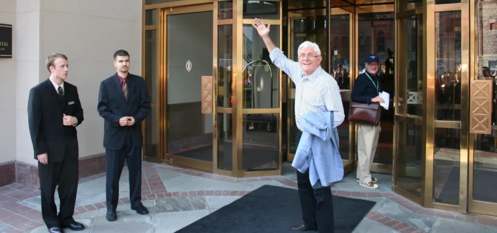 Phil Donahue waves to fans as he leaves his hotel during the Toronto Film Festival.