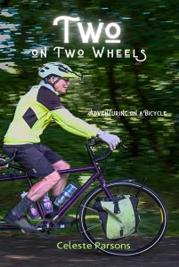 The cover of the book "Two on Two Wheels" by Celeste Parsons. The image is of a person in dayglo biking gear riding a bike with a blurry forest background. 