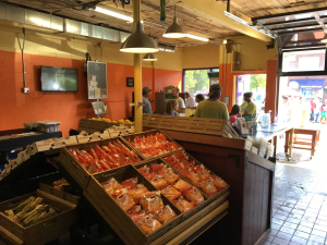 Shelves at a food pantry are stocked with packaged goods and produce.