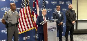 Ohio Gov. Mike DeWine (R) speaks at a press conference at Springfield City Hall alongside Ohio State Highway Patrol Colonel Charles Jones, left, Director of the Department of Public Safety Andy Wilson, second from right, and Springfield City School Superintendent Robert Hill, right