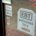 A sign behind a glass door reads "EBT welcomed here."