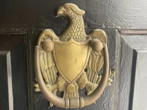 A knocker looks like a mythical bird on a door