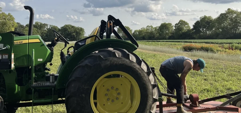 A farmer works on a tractor at Larissa Duprey's 12-acre farm in Yellow Springs.