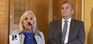 Donna and Jeff Heck at a suicide prevention press conference, with a photo of their daughter