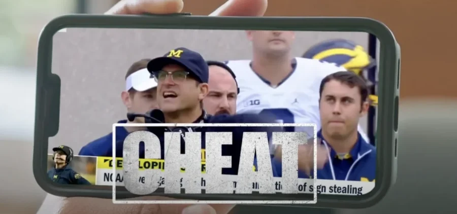 An aid to convince Ohioans to vote for a proposed change to the redistricting process shows former Michigan football coach Jim Harbaugh with the word Cheat over him.