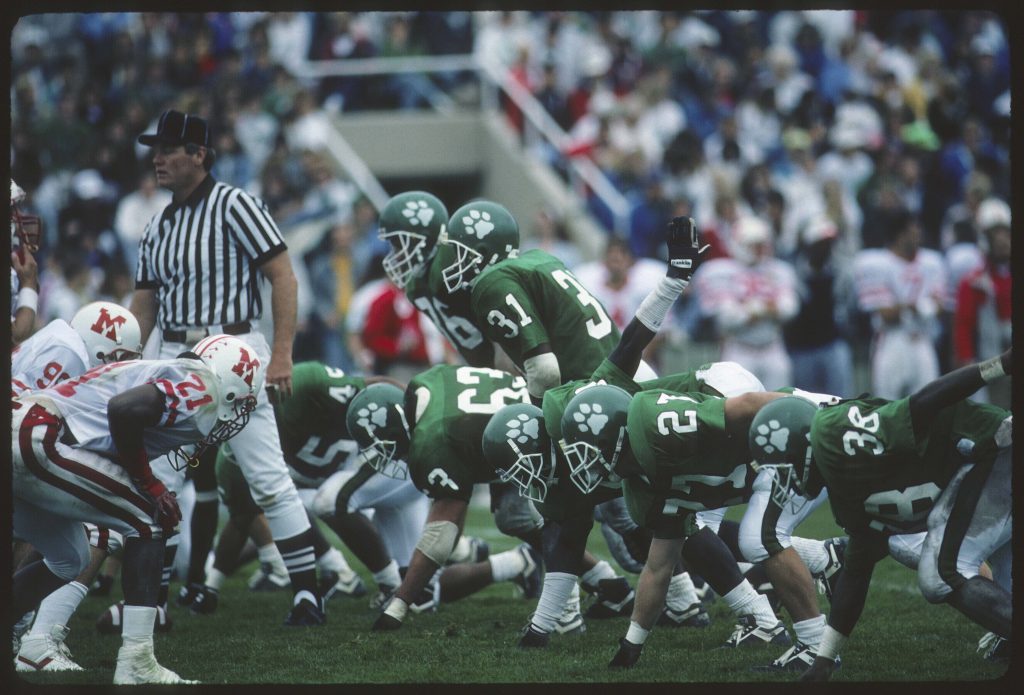 Referee stands on the line of scrimmage in Ohio's 1990 Homecoming game vs Miami. [Alden Library Archives]