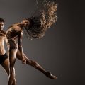 Two ballet dancers in mid performances. Woman's hair is flowing as she throws her head back