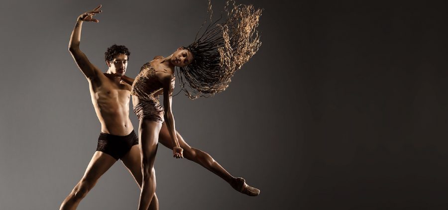 Two ballet dancers in mid performances. Woman's hair is flowing as she throws her head back