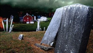 opld headstones in the foreground with farm in the distance