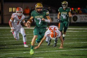 Athens quarterback Braeden Young juking a Nelsonville-York defender on the football field in 2023.