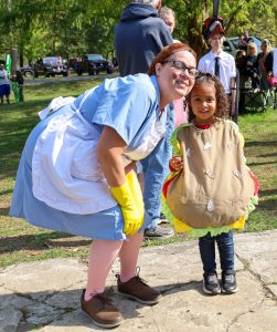 A mother and daughter dressed up as a lunch lady and a sloppy joe sandwich. 