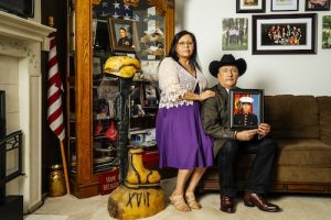 Adań (right) and Yolanda Gonzales are the parents of Sergeant Adań Gonzales, Jr., (seen in photo) a member of the 1st Battalion, 5th Marine Regiment, killed in action during Operation Enduring Freedom in Afghanistan on Aug. 7, 2011. Next to them is a curio cabinet filled with mementos of their son's service and a battlefield cross sculpture carved by chainsaw artist Anthony Marquez, a Marine veteran from Gonzales' unit. Marquez carved 17 such sculptures, all inscribed with the roman numeral XVII, for the 17 members of their unit killed in action. They are seen here in their home in Marysville, Washington, on Sat., April 13, 2024.