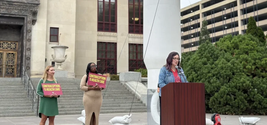 Jen Perez, the state director for Red Wine and Blue, stands behind a podium during a September 2024 press conference.