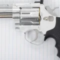 A handgun lays on a notebook.