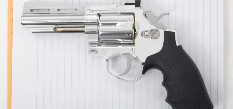 A handgun lays on a notebook.